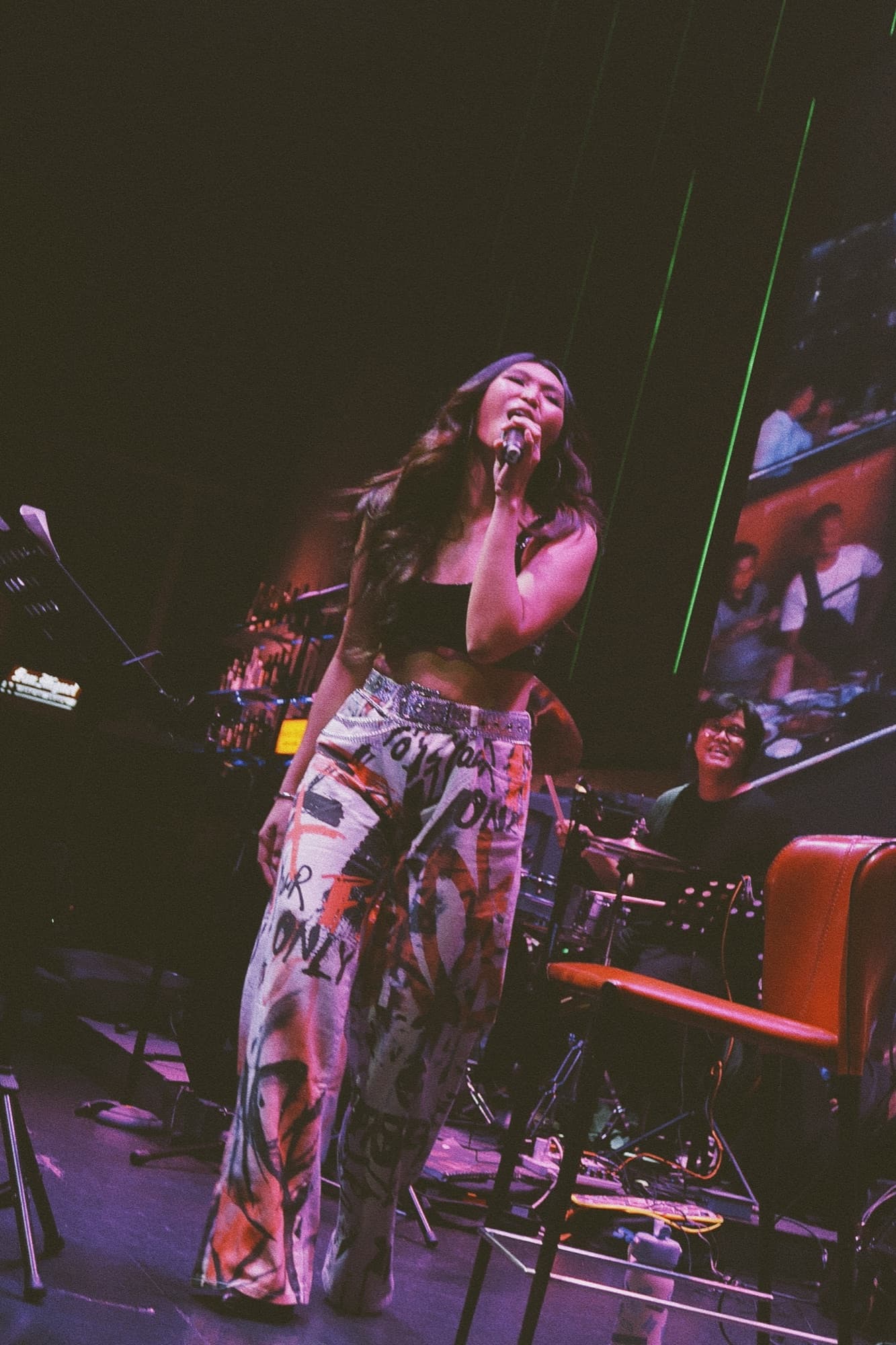 Lyra performing on a purple-lit stage